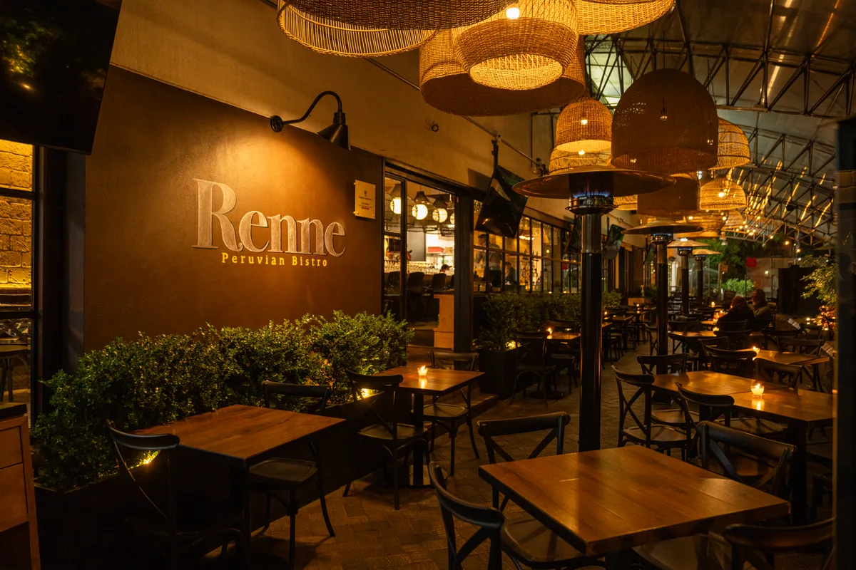 El salón y la terraza de Renne, con iluminación cálida y mesas listas para recibir
