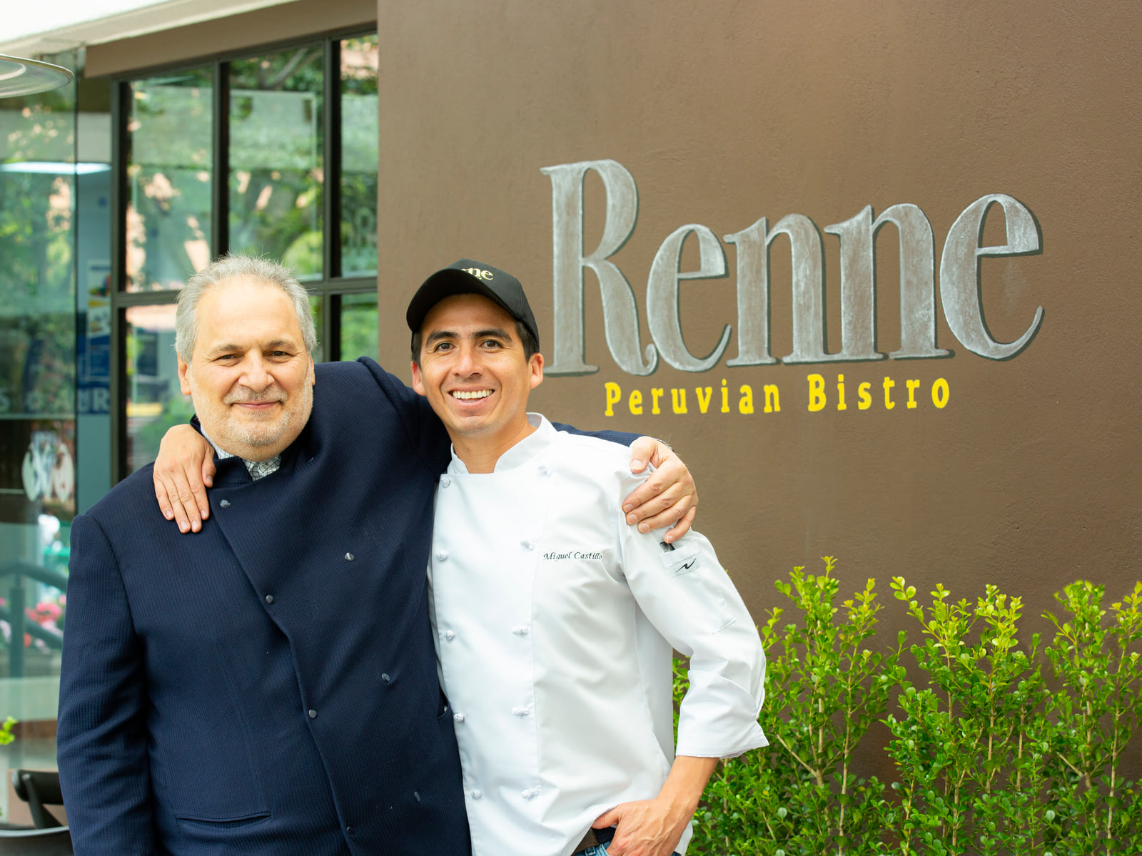 Carlos Renne Cure Lemaitre y Miguel Ángel Castillo Basto juntos frente al letrero de Renne Peruvian Bistro.