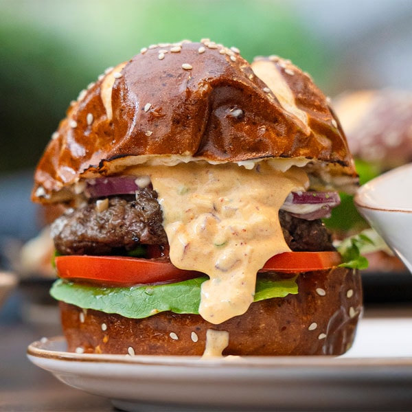 Hamburguesa La Chola Power de Renne con pan oscuro, carne, vegetales y salsa.