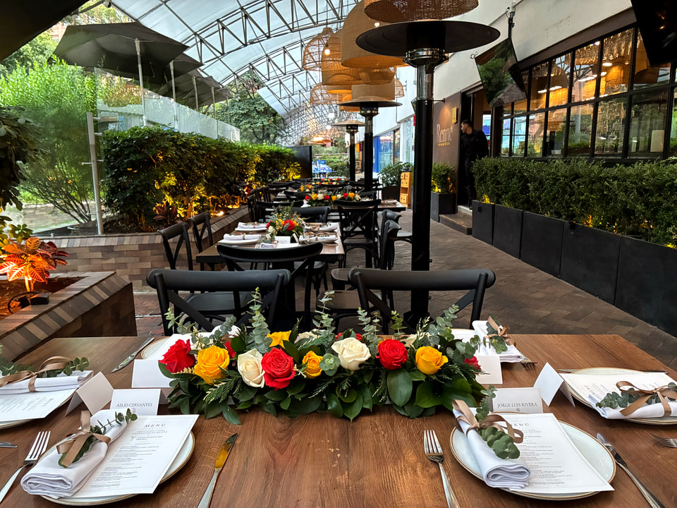 Terraza de Renne preparada con mesas, flores y vajilla para un evento privado.